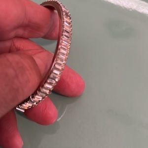 Silver bangle bracelet has a safety chain a clip lock